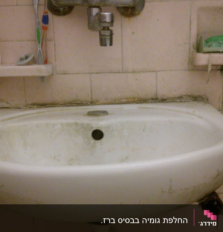 כיור עם ברז חלוד וצנרת מתחת